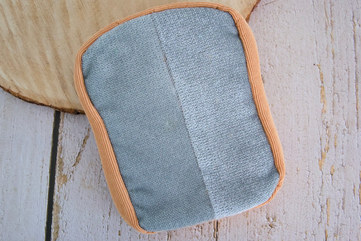 Toast-shaped Butter Mitten grooming accessory designed to remove pet hair from household surfaces and keep your home cleaner.