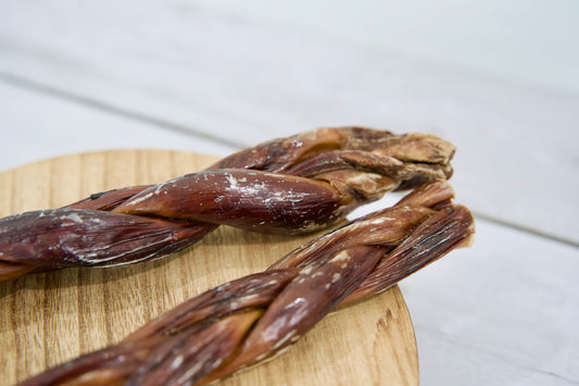 Two braided dog treats made from dried beef.|Deux friandises tressées pour chiens à base de bœuf séché.