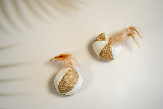 Natural looking cat balls with feathers on top and neutral colors. | Balles pour chat en tissus mou d'aspect naturel avec plumes sur le dessus et aux couleurs neutres.