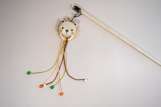 Cat teaser in the shape of a cat's head, leather rope and wooden beads. | Agace-chat en forme de tête de chat avec cordelettes en cuir et perles en bois.