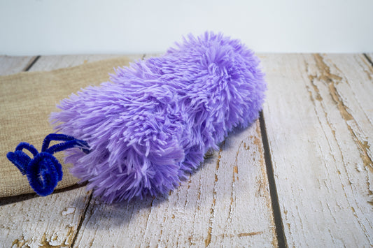 Side view of purple cat plush toy in the shape of a caterpillar and filled with catnip. | Vue latérale d'une peluche mauve pour chat rempli d'herbe à chat.