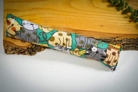 Green cat pillow with cat and bird patterns. | Coussin vert pour chat avec motifs chats et oiseaux.