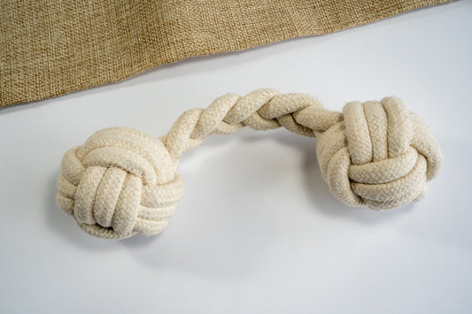 Cotton rope dog toy with monkey fists at the ends. | Jouet en corde de coton pour chien avec poings de singe aux extrémités.