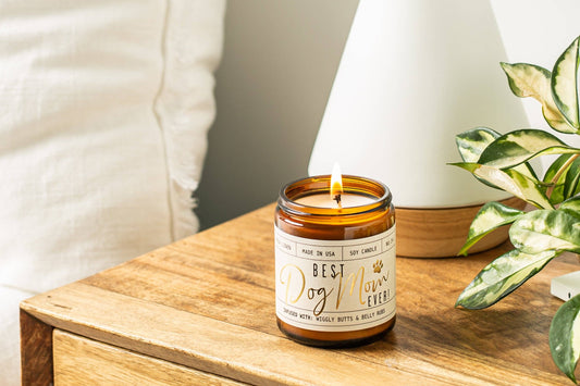 Dog-themed candle labeled Best Dog Lover Ever on a wooden surface.|Bougie sur le thème des chiens, portant l'inscription Best Dog Lover Ever, posée sur une surface en bois.