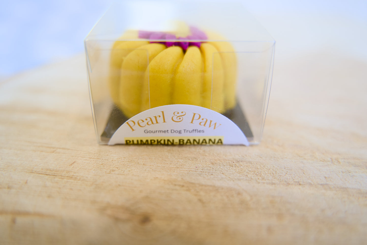 Yellow dog truffle pumkin-banana made by Pearl & Paw branding on a wooden surface.