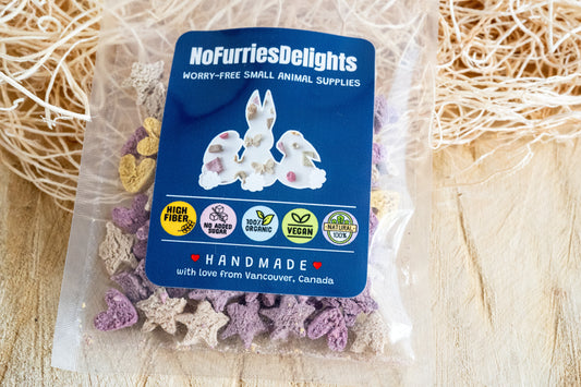 Star and heart shaped bites in a Lucky variety pack, handmade food for bunnies and guinea pigs high fiber, no added sugar, 100% organic, natural and vegan. | Bouchées en forme d'étoile et de cœur dans un packet, gâteries fait à la main pour lapins et chincillas, riche en fibres, sans sucre ajouté, 100% biologique, naturel et végétalien.