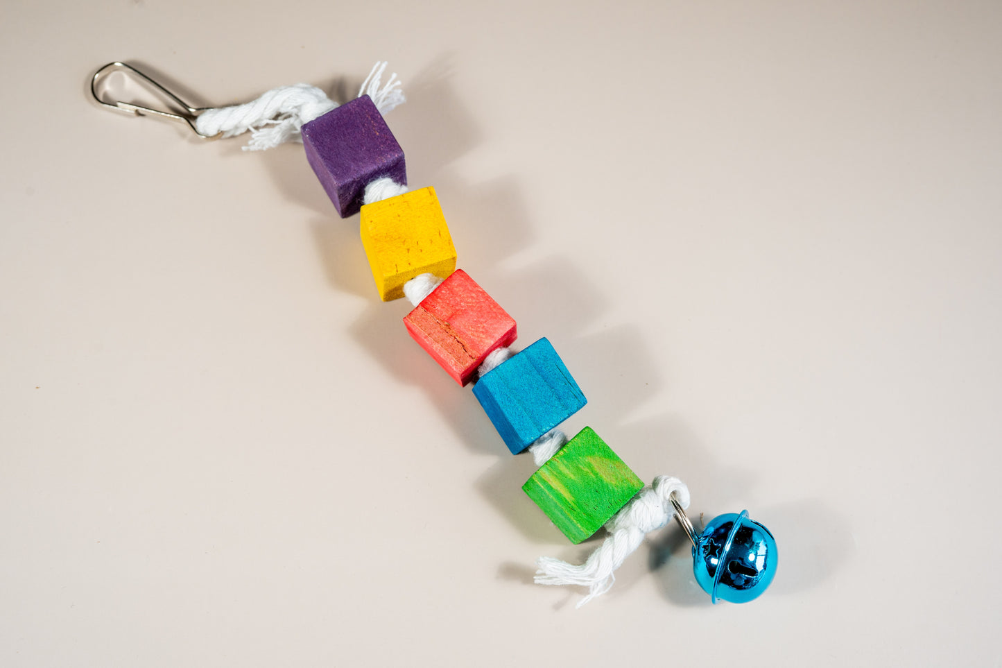 Jouet à mâcher pour oiseaux avec clochette et cubes en bois.