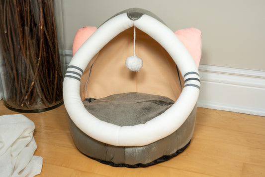 Plush bed house for cats and dogs with pink cat ears. | Maison-lit en peluche pour chats et chiens de couleur grise et oreilles de chat roses.