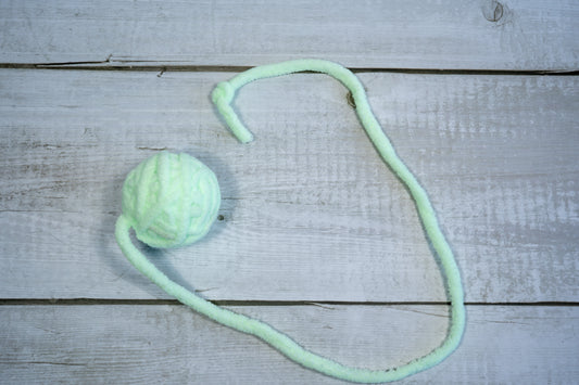 Small pastel green wool ball with tail for cats. | Petite pelote de laine verte pâle avec queue pour chat.