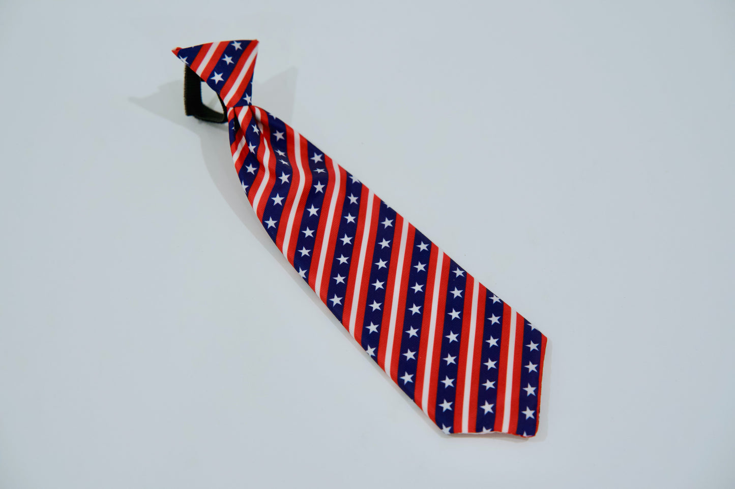 Cravate pour chien à motif de drapeau américain sur fond gris clair.