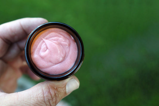Hand holding a small container with strawberry pet toothpaste.|Main tenant un petit récipient contenant du dentifrice pour animaux à la fraise.