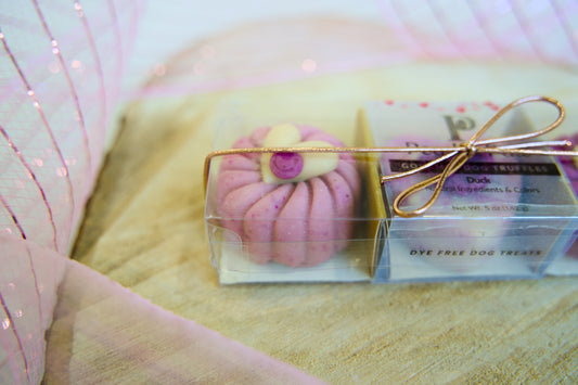 Pink dog cake with gold bow.|Gâteau pour chien rose avec un nœud doré.