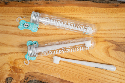 Toothbrush for small dogs in its container placed on a wooden board. | Brosse à dents pour petit chien dans son contenant posé sur une planche de bois.