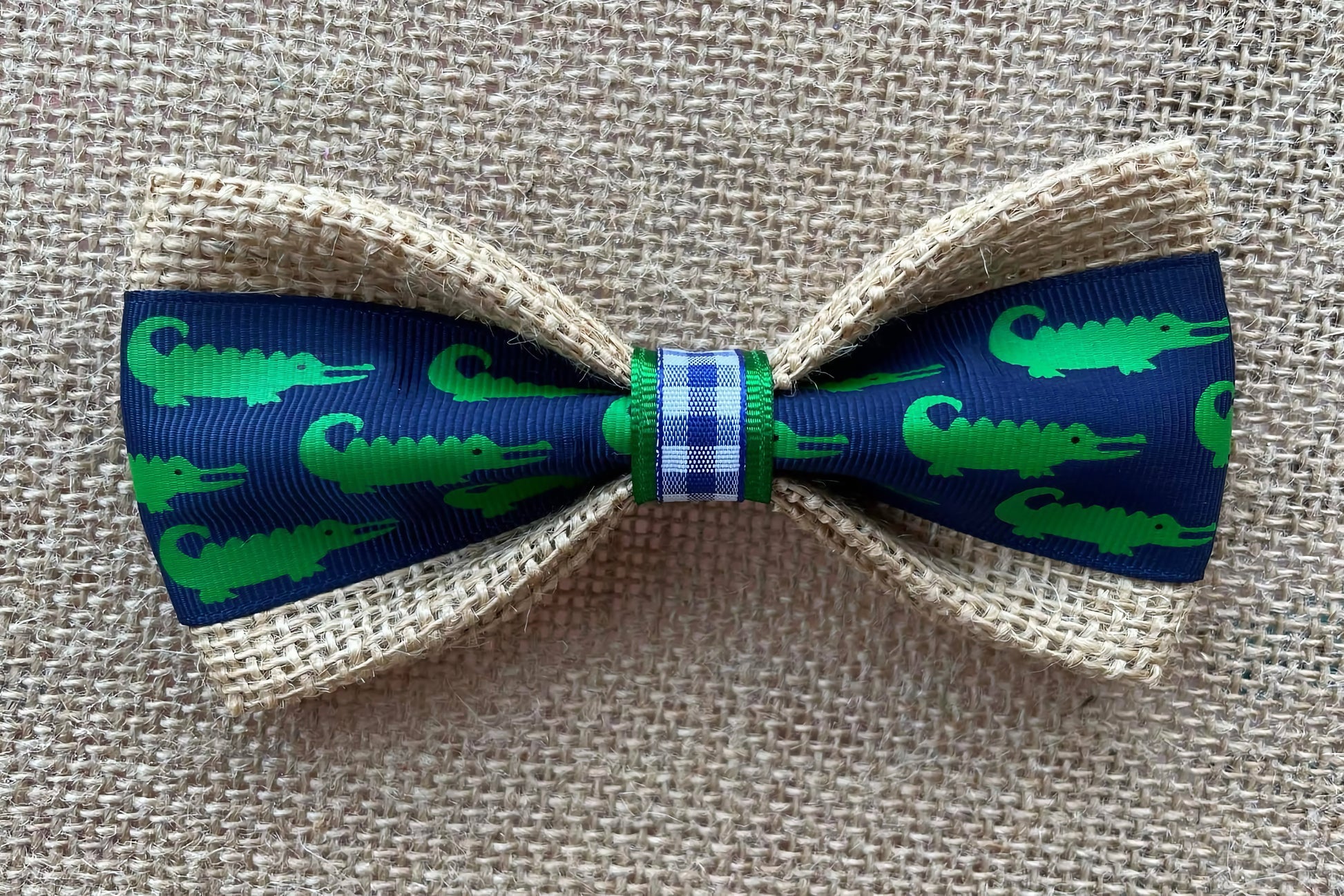 Bow tie for pets with green alligator pattern on blue background.