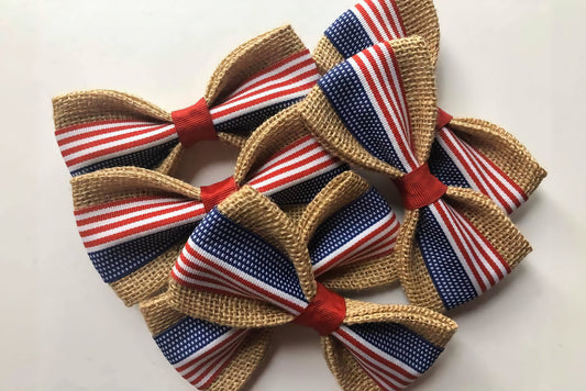 Four decorative pet bow ties with red, white, and blue patterns on a light background.|Quatre nœuds papillon décoratifs pour animaux, à motifs rouges, blancs et bleus sur fond clair.