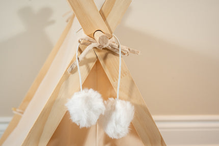 Vue rapprochée des pompons décoratifs blancs super doux de la tente beige pour animaux.
