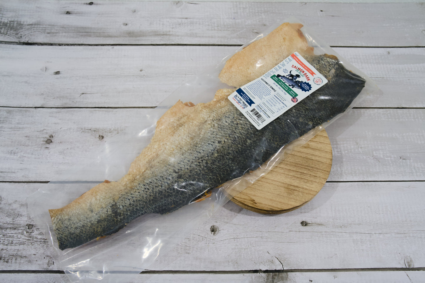 Un filet de saumon entier séché (avec la peau) pour chiens et chats, dans son emballage en plastique transparent.