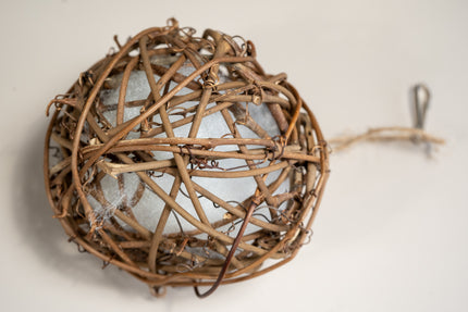 Vue rapprochée de la boule en rotin avec mousse intégrée pour divertir les oiseaux en cage.