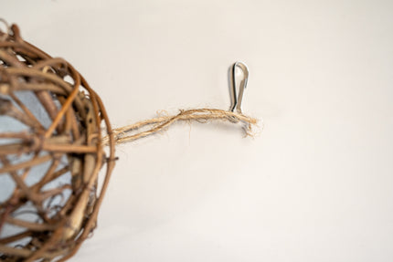 Vue rapprochée de la corde et du crochet pour accrocher la balle en branches de vigne pour oiseaux.