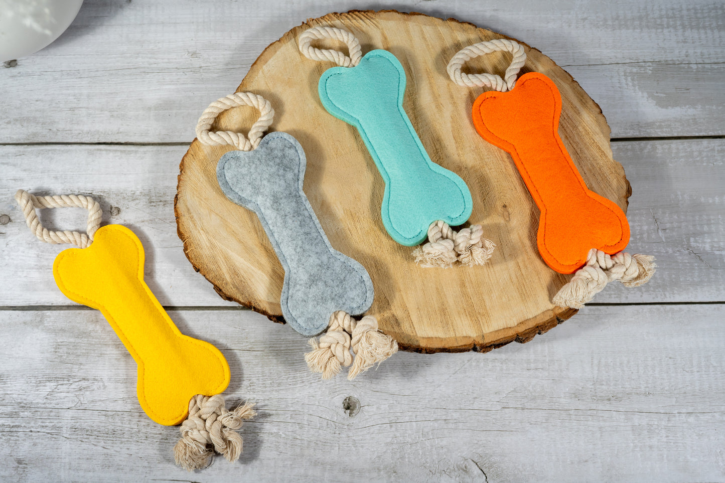 Felt bone dog toy with sturdy rope at the ends to encourage pulling.
