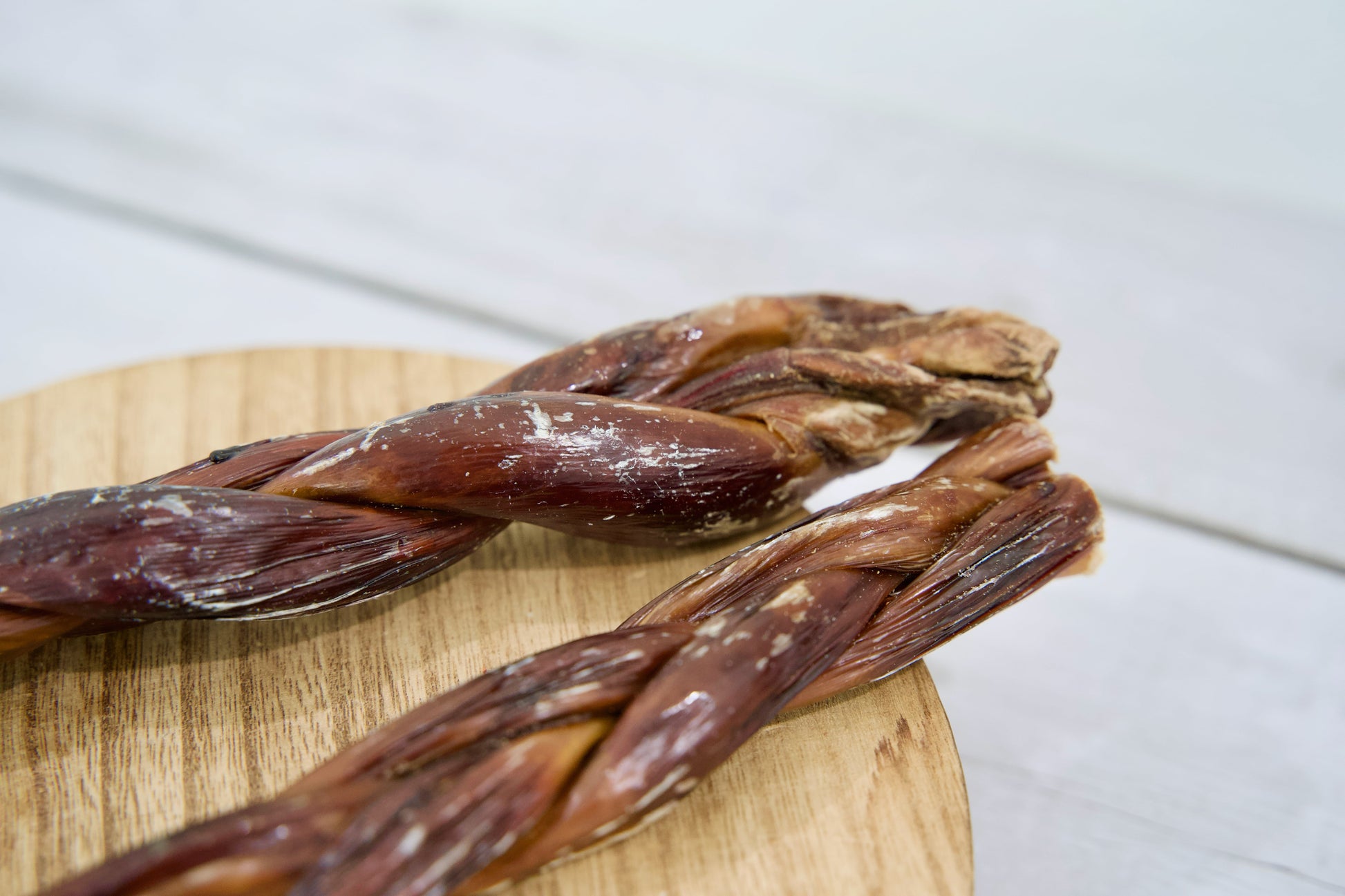 Two braided dog treats made from dried beef.