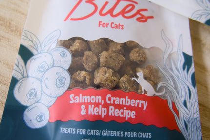 Gros plan sur un sachet de friandises pour chats à la recette saumon, canneberge et varech.