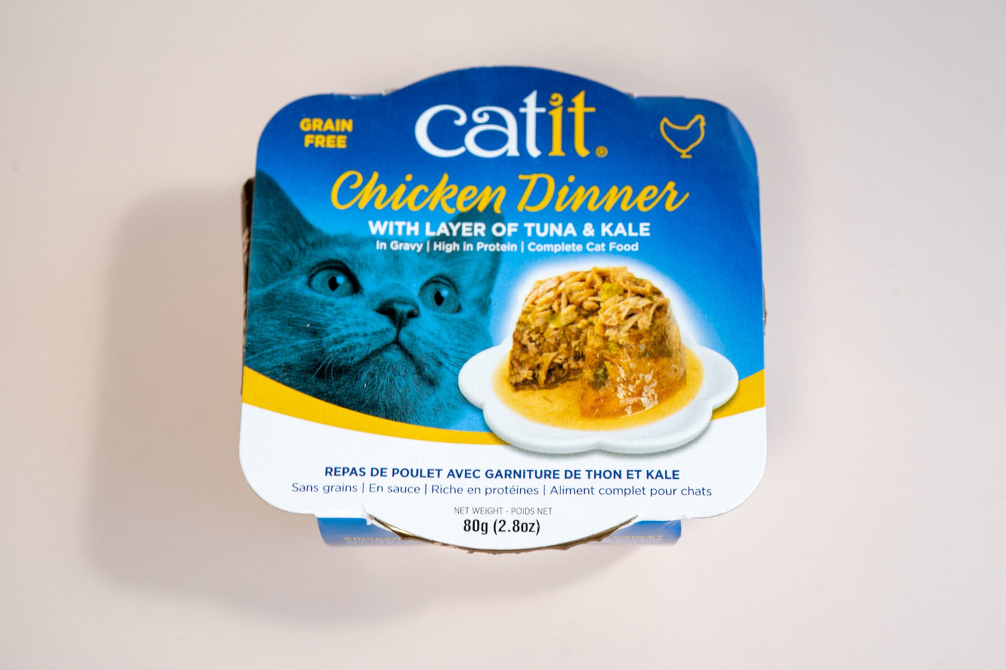 Vue de face de la nourriture humide pour chats Catit Chicken Dinner avec une couche de saveur de thon et kale.