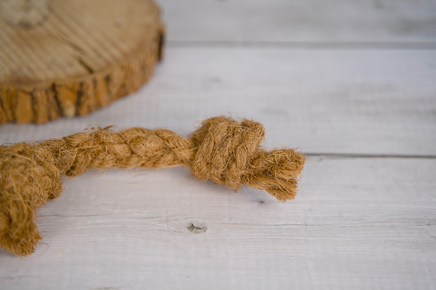 Jouet pour chien en corde de coco sur une surface en bois.