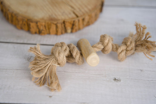 Dog toy made of rope and wooden sticks on a wooden surface.|Jouet pour chien composé de corde et de bâtonnets en bois, posé sur une surface en bois.
