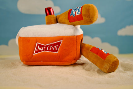 Dog playing with plush beer cooler toy and squeaky bottles.