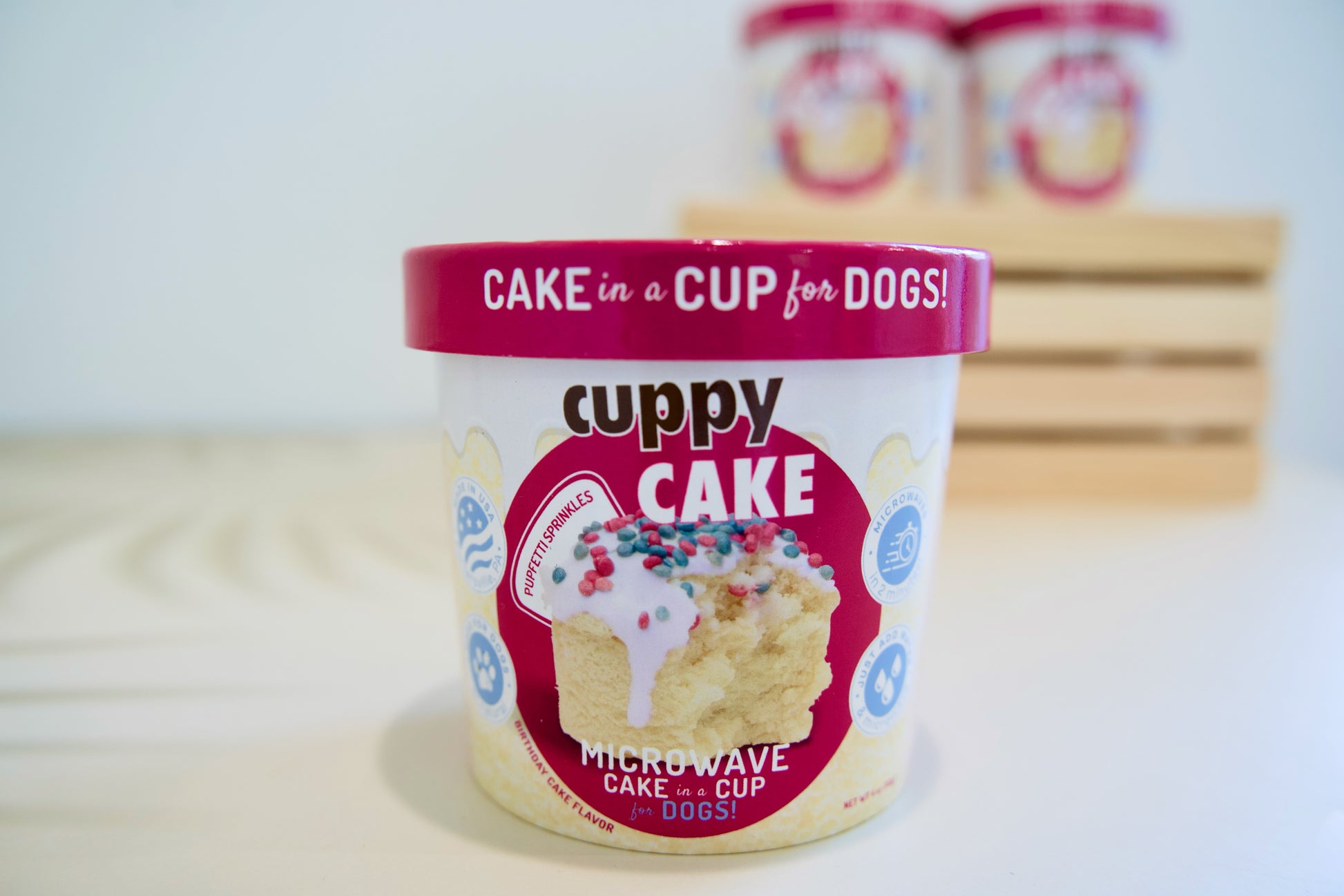 Cuppy Cake, gâteau d'anniversaire pour chien à cuire au micro-ondes dans une tasse, avec couvercle rose, sur fond blanc.