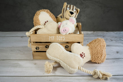 Panier en bois avec jouets en peluche pour chiens.