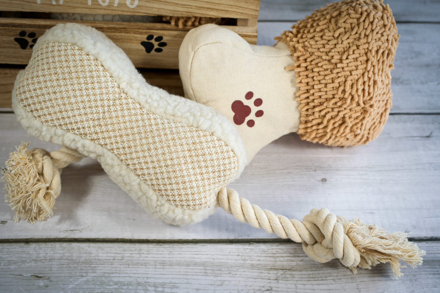 Close-up view of two bone-shaped plush and rope dog toys.