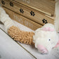 White and brown pig-face-shaped plush dog toy with 2 different textures.
