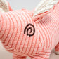 Close-up view of pink pig plush dog toy.