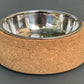 Cork dog bowl with a metal interior on a gray background.