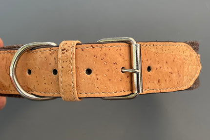 Collier pour chien en liège marron avec boucle en métal sur fond gris.
