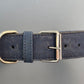 Navy blue cork dog collar with brass buckle on a gray background.