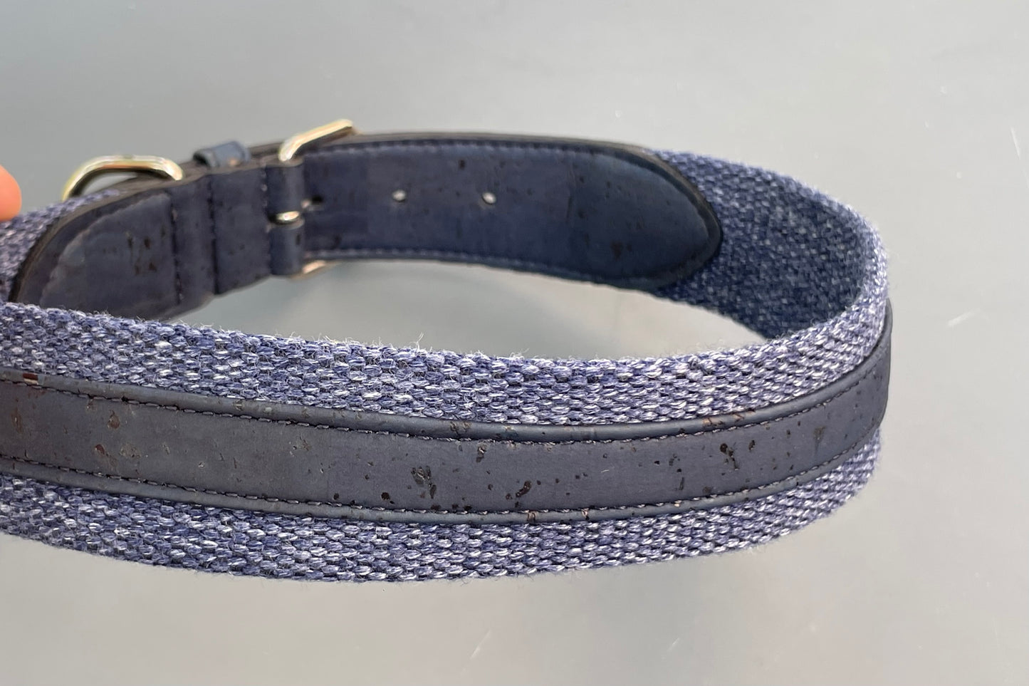 Navy blue dog collar with cork texture on a gray background.