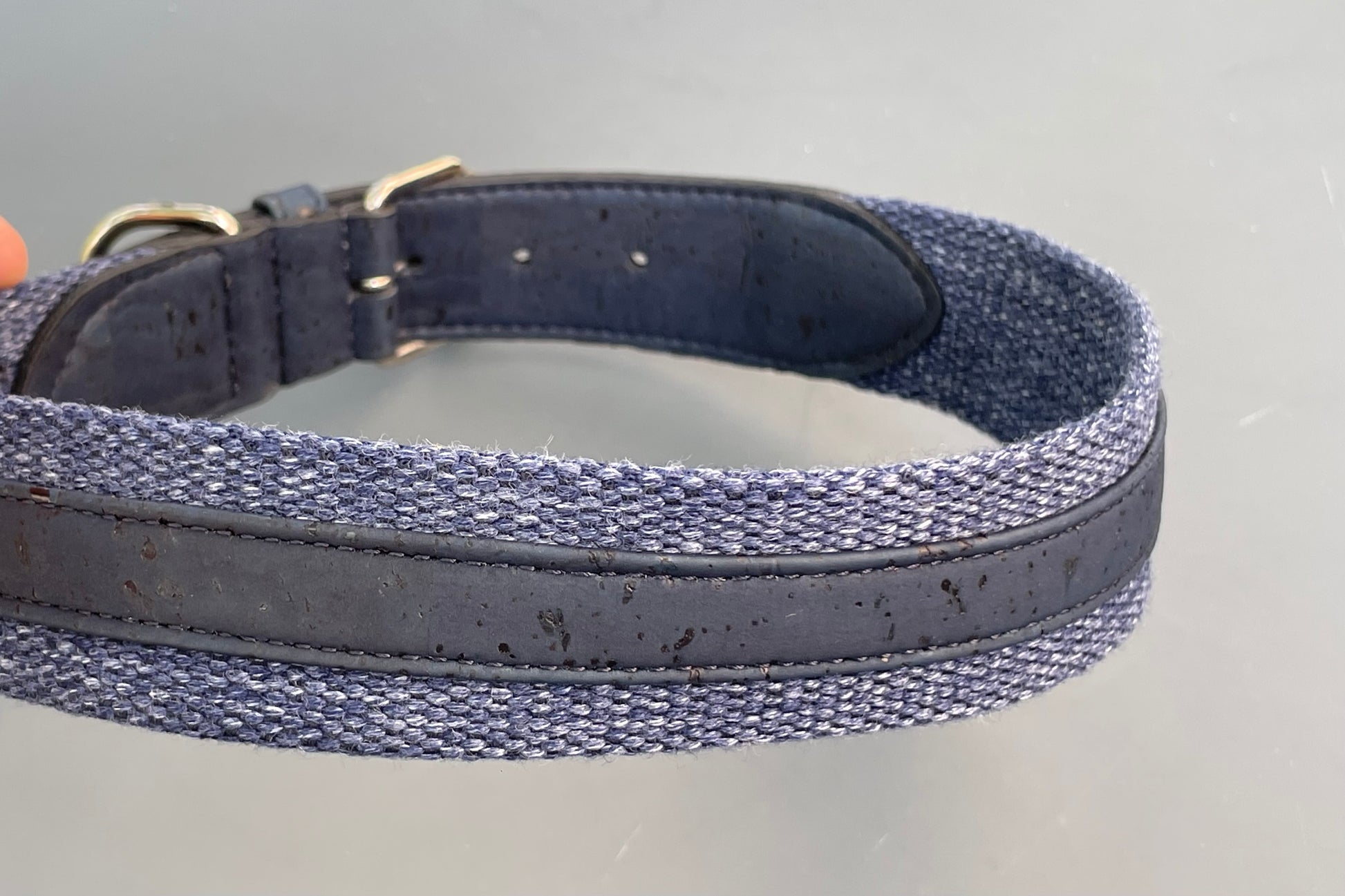 Navy blue dog collar with cork texture on a gray background.