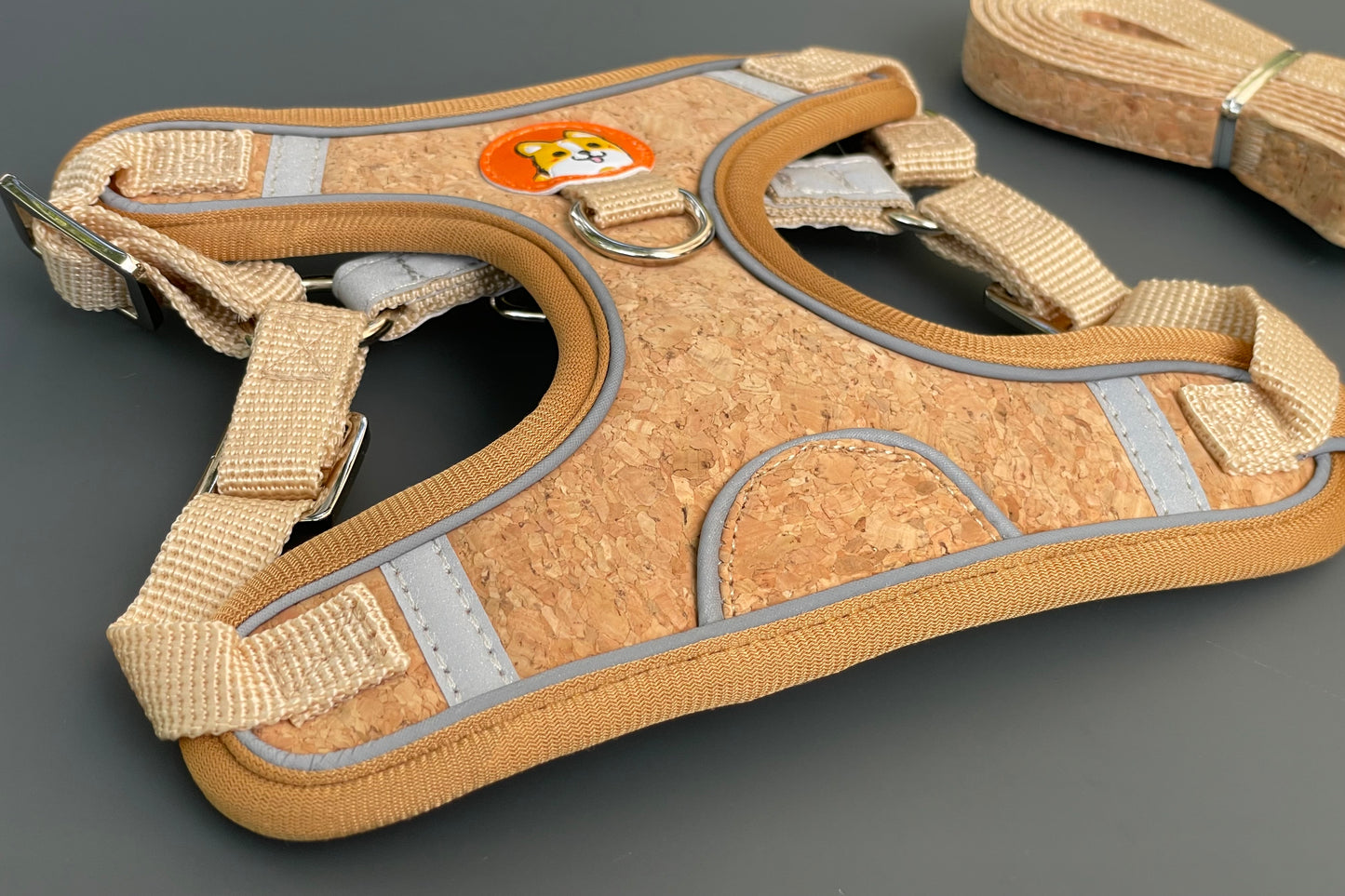 Harnais en liège pour chien avec bandes réfléchissantes sur fond gris.