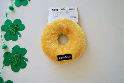 Yellow donut-shaped toy with Zippy Paws branding on a white background with green shamrock decorations.