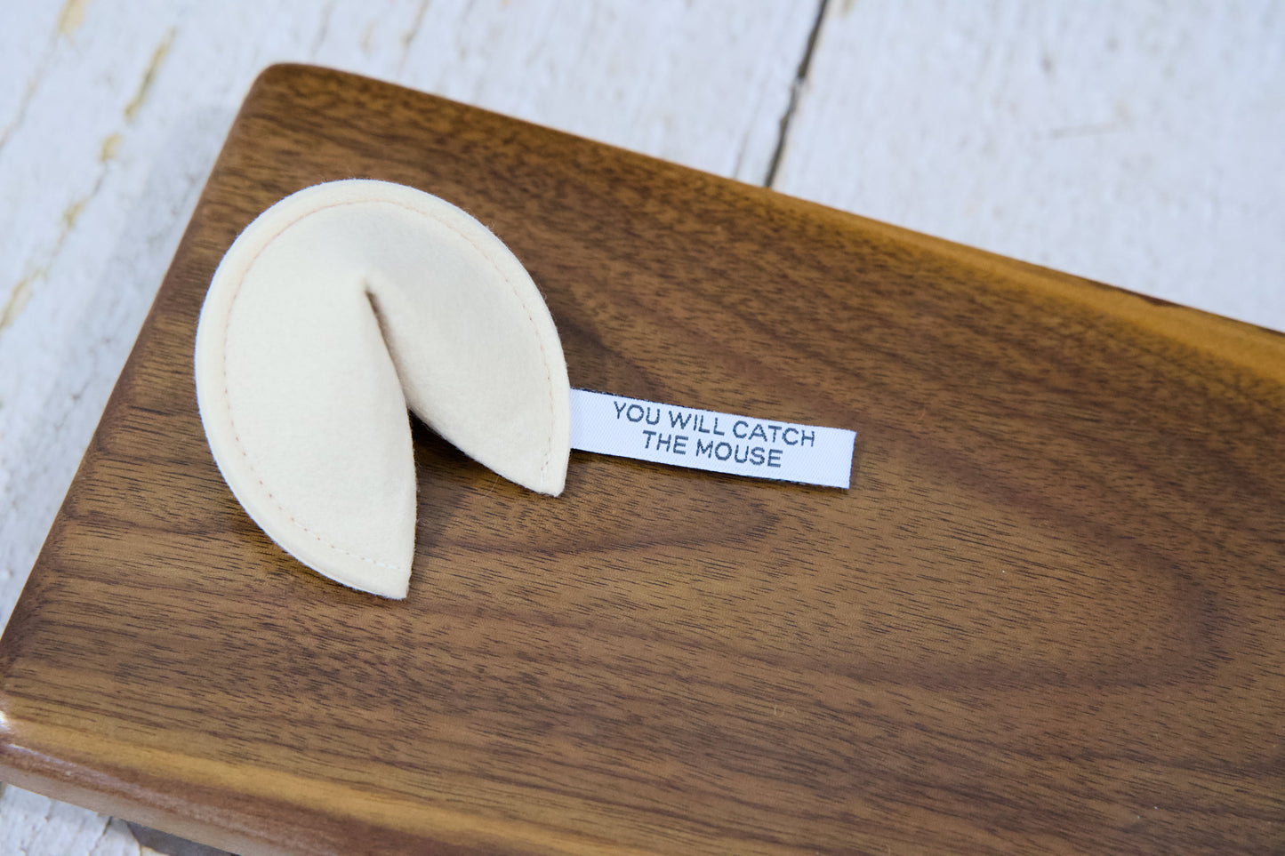 A fortune cookie cat toy with catnip and a tag that reads YOU WILL CATCH THE MOUSE.