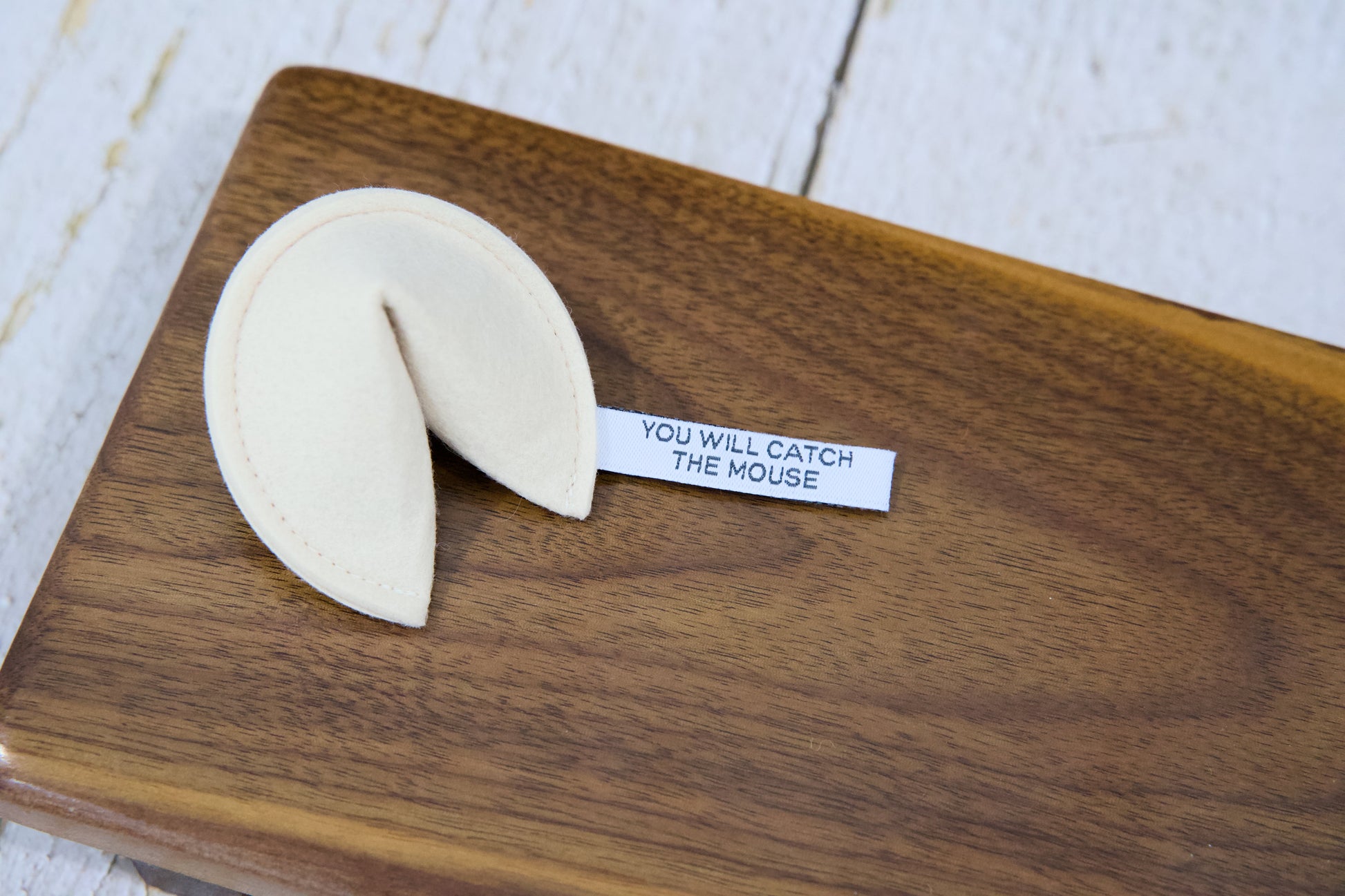 A fortune cookie cat toy with catnip and a tag that reads YOU WILL CATCH THE MOUSE.