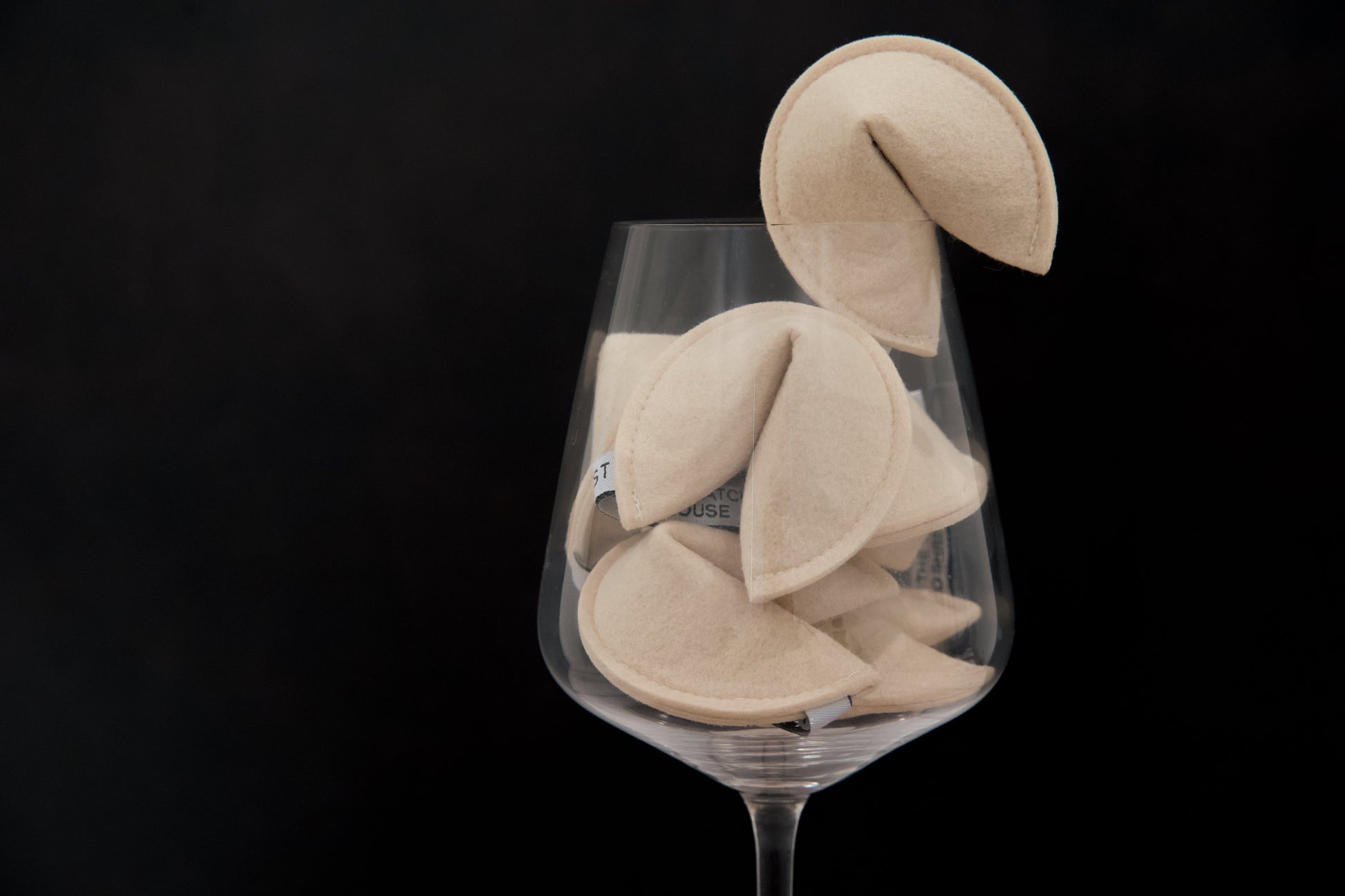 Catnip-filled cat toys shaped like fortune cookies, in a wine glass.