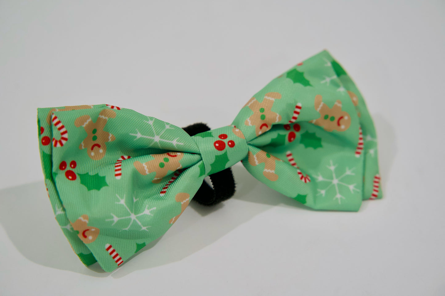 Nœud papillon vert pour animal de compagnie avec des motifs de Noël sur fond blanc.