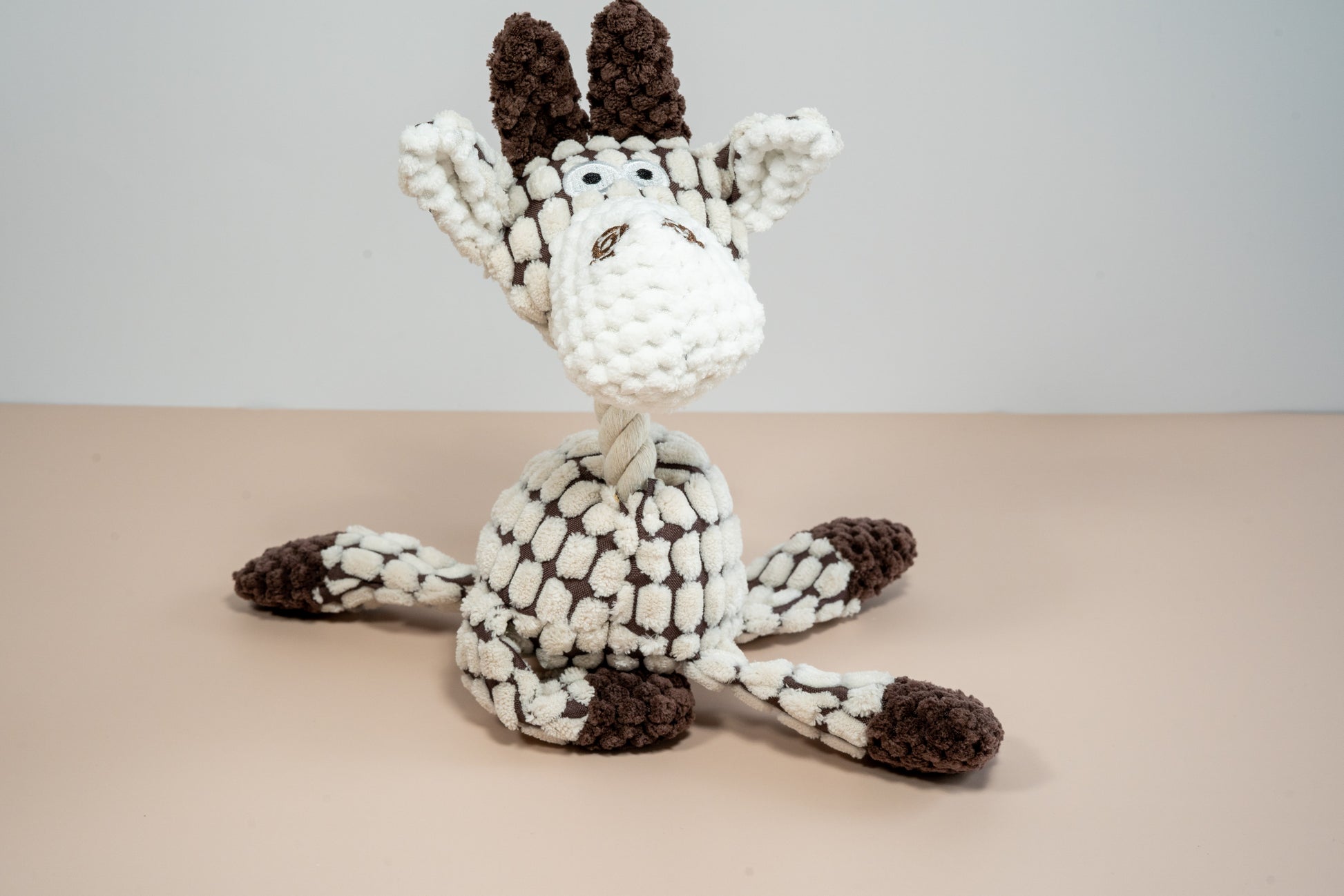 Plush dog toy in giraffe shaped with rope neck. | Jouet en peluche pour chien en forme de girafe avec cou en corde de coton.