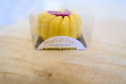 Friandise pour chien à la citrouille et banane, de la marque Pearl & Paw, présentée sur une surface en bois.