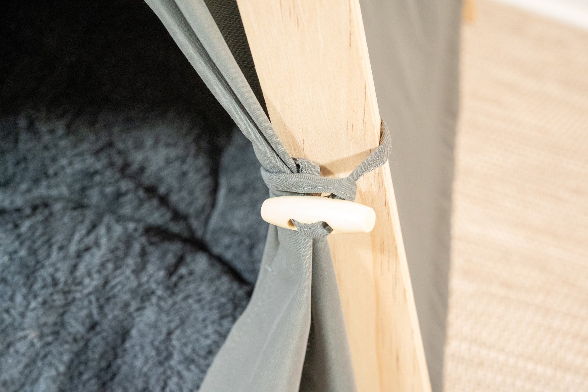 Close-up view of gray pet tent curtain clip. | Vue rapprochée de l'attache des rideaux de la tente grise pour animaux.