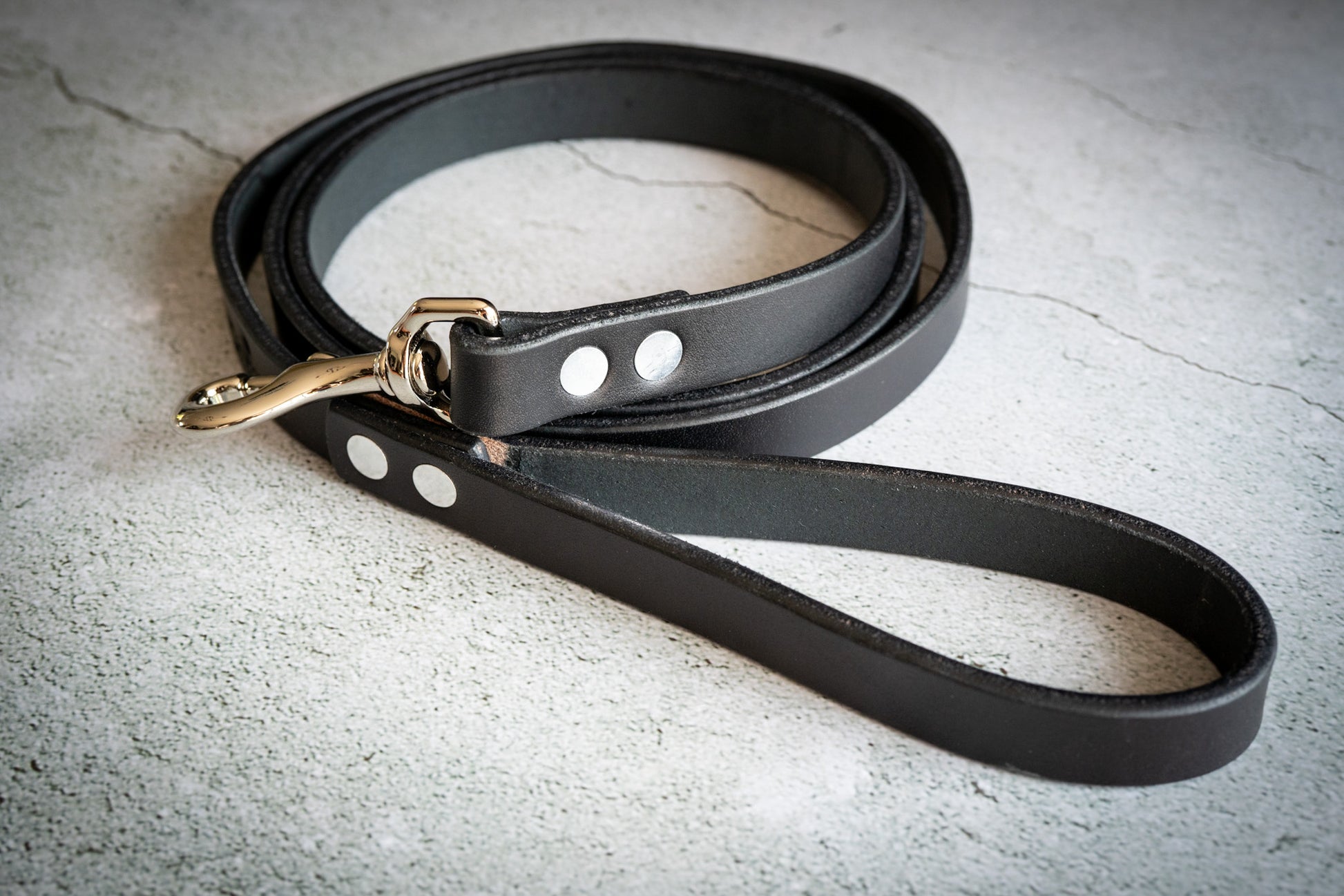 Uncoiled handmade black leather dog leash. | Laisse pour chien en cuir noir faite à la main.